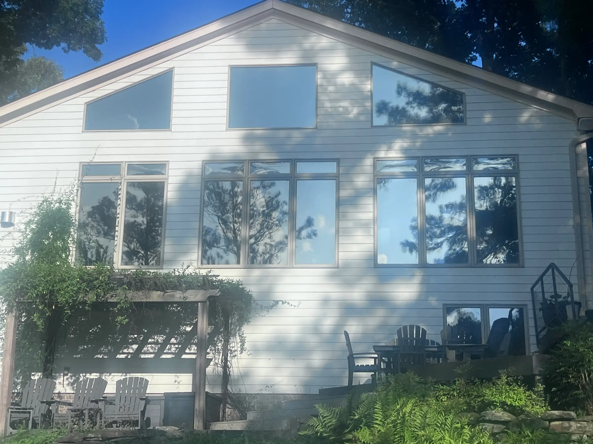 Residential home in Norfolk with large, reflective, sun-protective windows.